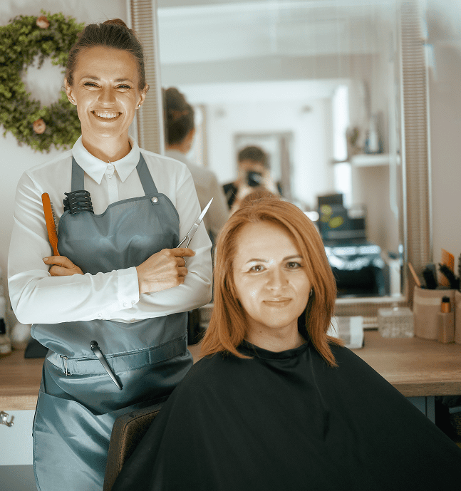 Smiling stylist with customer in chair