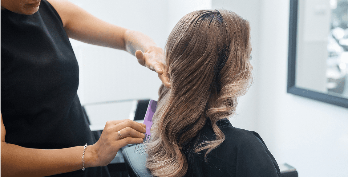 Hairdresser styling long blonde curls