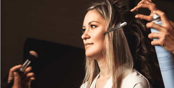 Woman getting makeup and hair styled