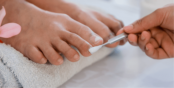 Pedicure session with white nail polish
