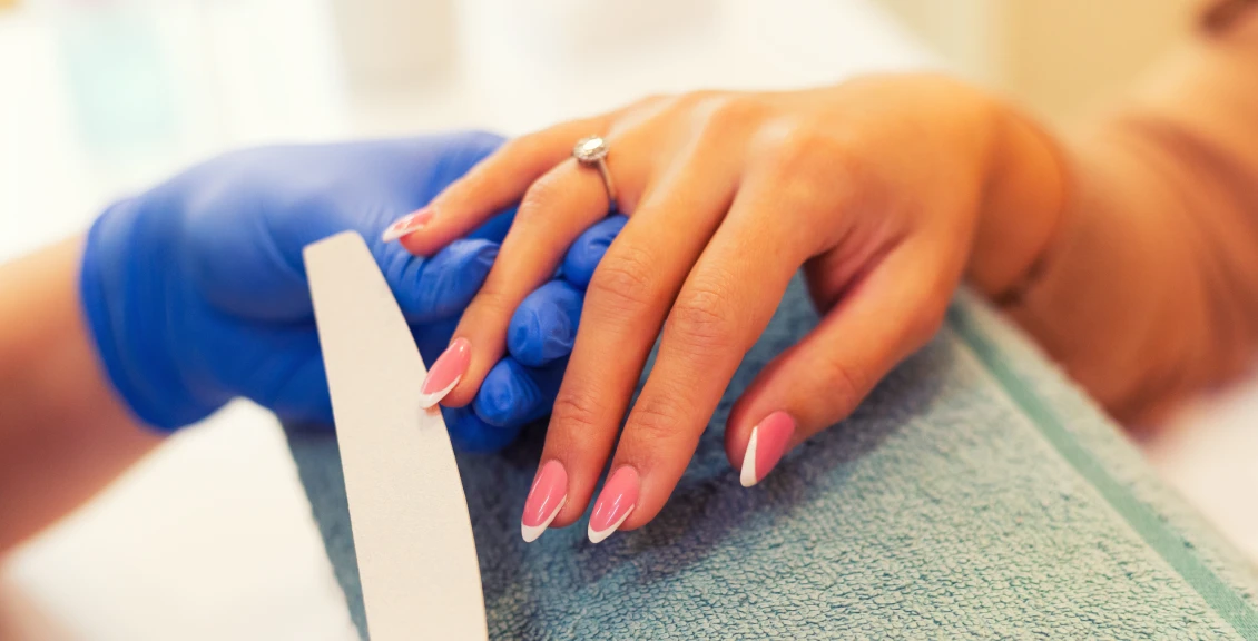 Hand with ring getting nails filed