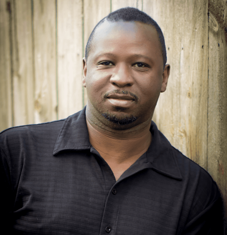 Man in black shirt by wooden wall